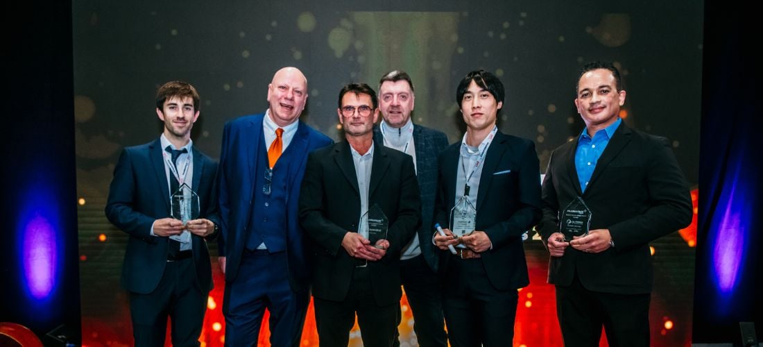 Two pharma professionals holding award on stage at Pharmapack event