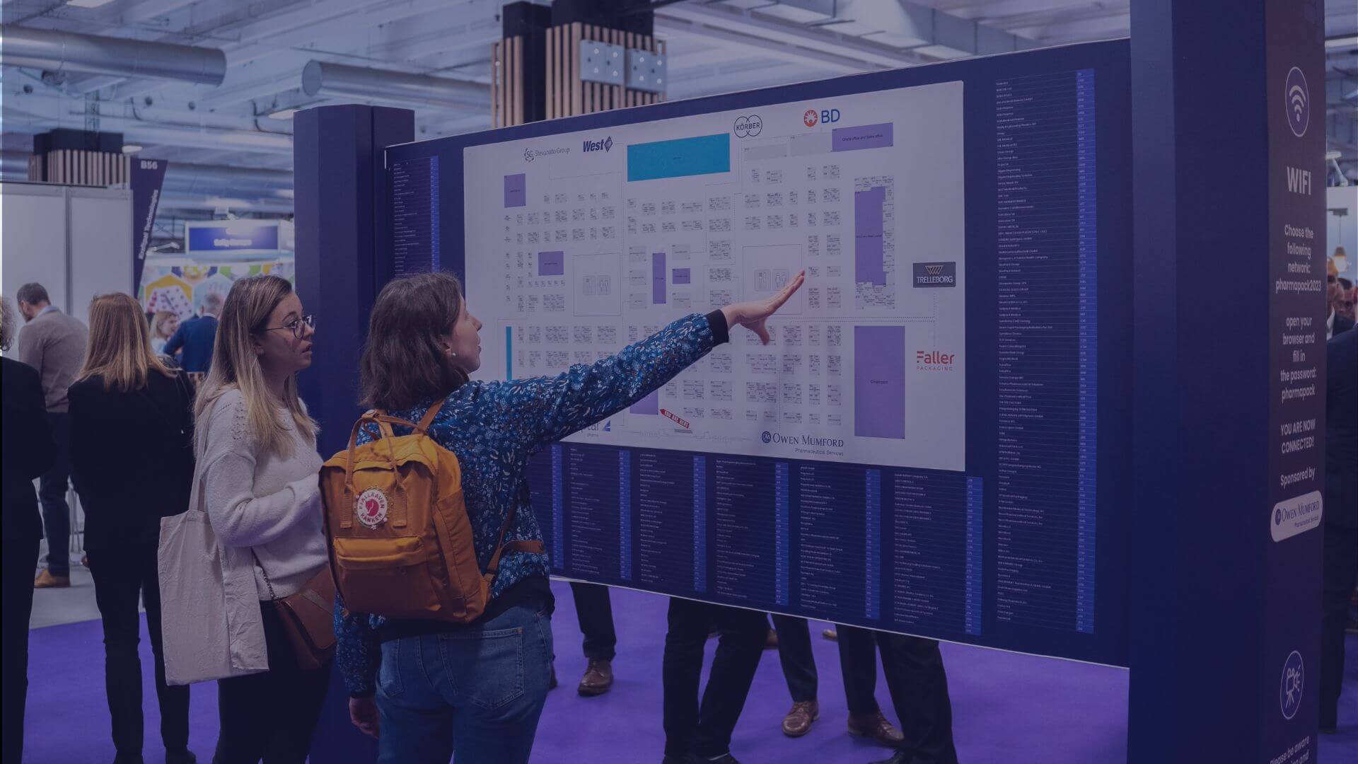 People standing at a product exhibition stand at a Pharmapack event