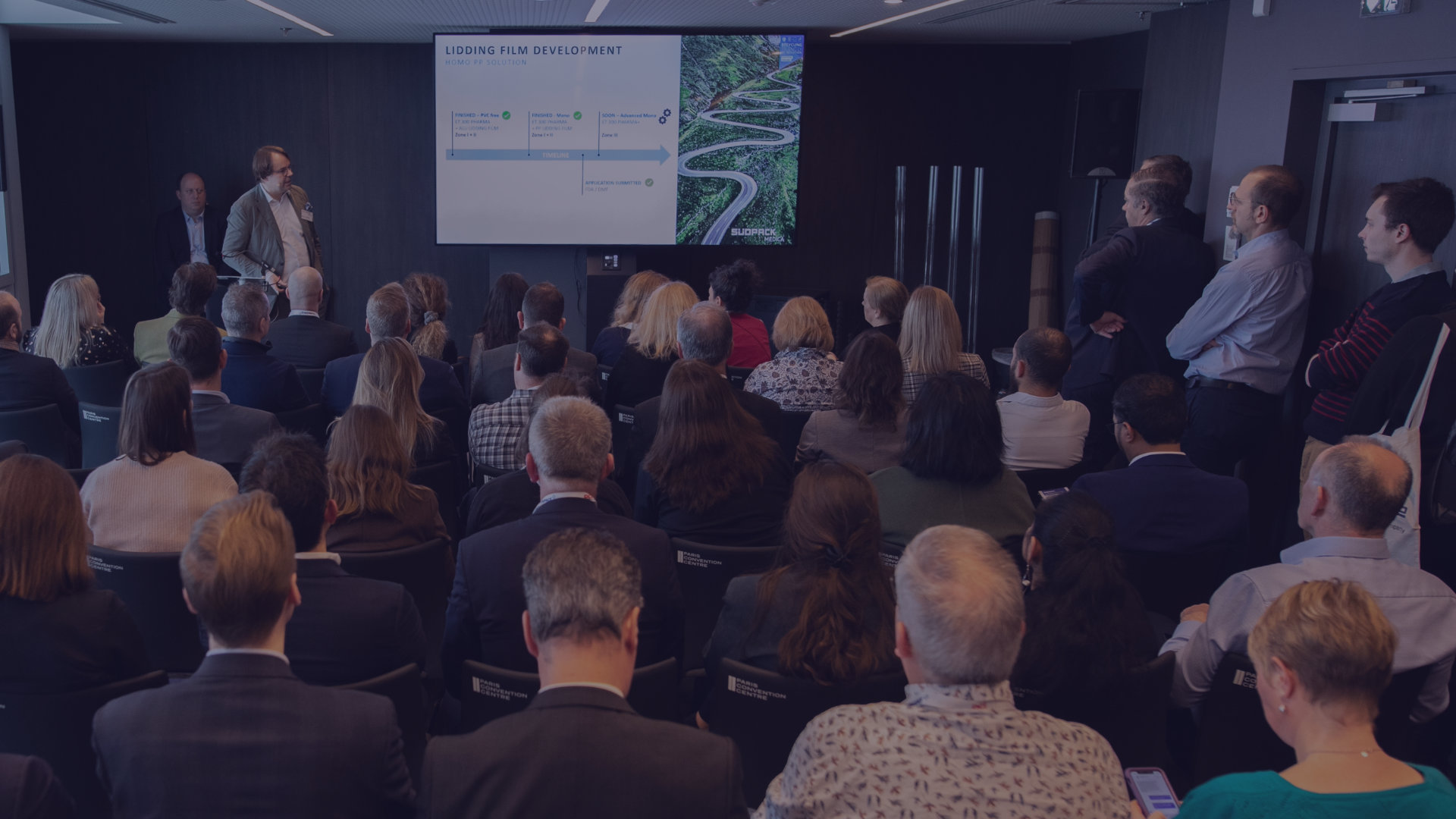 Room filled with Pharma professionals watching a talk presentation